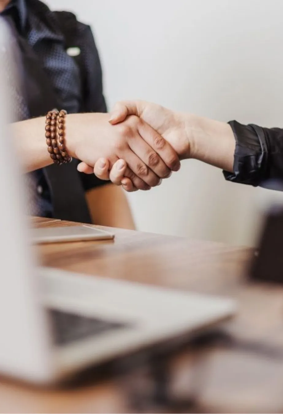 Business handshake over a wooden desk